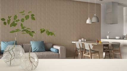 White table top or shelf with glass vase with hydroponic plant, ornament, root of plant in water, branch in vase, house plant, kitchen and living room background, interior design