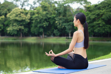 Portrait young asian woman practicing yoga on nature