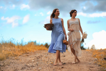 Two girls in dresses in autumn field