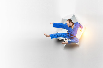 Fototapeta premium Young male practising karate . Mixed media