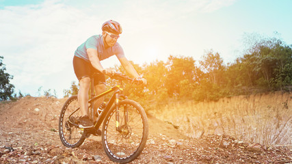 Man is riding bicycle, on the background of rocky trail in mountain area bike on trail at evening.mountain bike racing.healthy lifestyle.xtreme sports.vintage tone.selective focus.