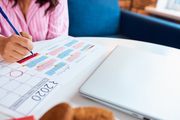 young pretty future mother with calendar at home and waiting impatiently for her baby's due date,...