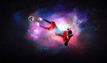 Boy playing soccer hitting the ball