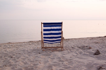 Sunbed on the beach at sunset near the sea.