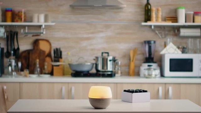 Essential oils diffuser for aromatherapy working on the kitchen table top. Aroma health essence, welness aromatherapy home spa fragrance tranquil theraphy, therapeutic steam, mental health treatment