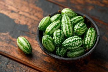 Freshly picked Cucamelon in rustic bowl on wooden table