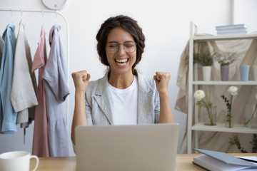 Front view overjoyed emotional young businesswoman in eyeglasses celebrating online lottery win....