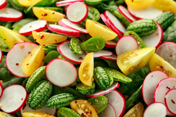 Cucamelon salad with radish, tomato, spinach and mustard dressing. Healthy food.