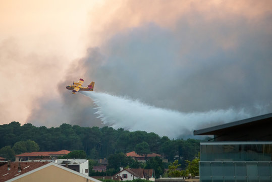 BAYONNE, FRANCE - 30 JULY, 2020: A Canadair CL-415 from the French Securite Civile came from Marseille to help tackle the Chiberta forest fire in Anglet. Here dropping water on the fire.