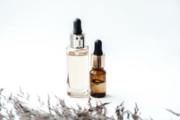 Glass bottles with oil for face and body care on white background. Natural cosmetics. Photo content