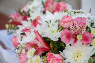 Bride's wedding bouquet of white flowers and pink orchids. Bouquets for bridesmaids. White daisies.