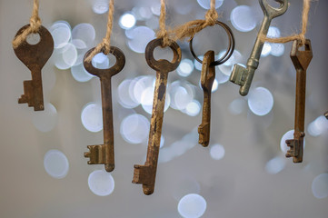 Old rusty keys hanged on the ropes with blurred lights background