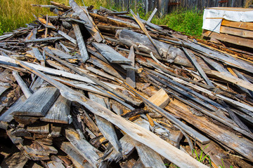 Forest pines and spruces. Piles of logs, logging woodworking industry. Wide constriction or panorama of wooden trunks. Stack of logs at a sawmill in rural areas