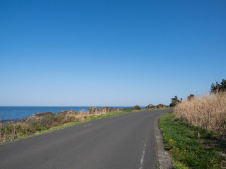 A view of the trail along the ocean with blue sky. The Michinoku Coastal Trail in Aomori Prefecture, Japan.