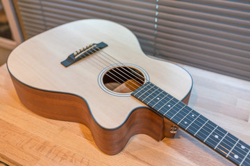 Acoustic guitar on wooden table in the room,Travel accessories concept
