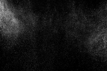 Abstract splashes of water on black background. Freeze motion of white particles. Rain, snow overlay texture.