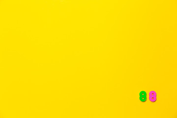 A green and pink plastic toy number eighty-eight is located in the lower right corner on a yellow background