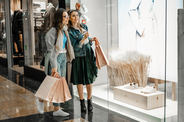 Trade, buyers. Two beautiful girls make purchases in a shopping center, go shopping. The joy of...