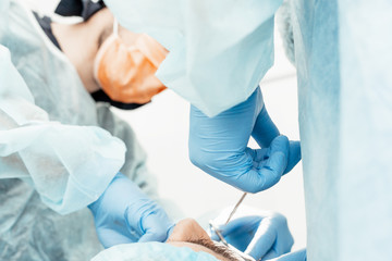 Dentists will perform an operation, implant placement. Real operation. Tooth extraction, implants. Professional uniform and equipment of a dentist. Healthcare Equipping a doctor’s workplace. Dentistry