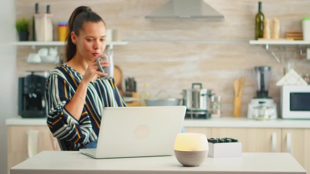 Working in the kitchen with essential oils diffuser steaming. Aroma health essence, welness aromatherapy home spa fragrance tranquil theraphy, therapeutic steam, mental health treatment