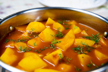 Tomato and potato gravy served in a stainless bowl
