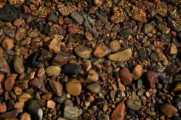 Background of stones underwater on river bottom, warm summer light