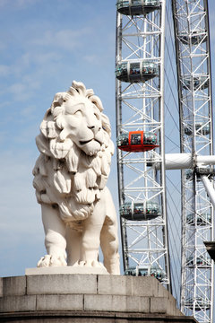 London, UK, August 19, 2012: The South Bank Lion and London Eye in Westminster on the River Thames which are popular travel destination tourist attraction landmark stock photo image