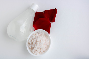 Red petals and Pink salt in a small white porcelain bowl.space for text.