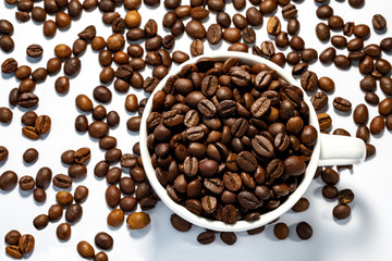 cup with coffee beans on white background top view