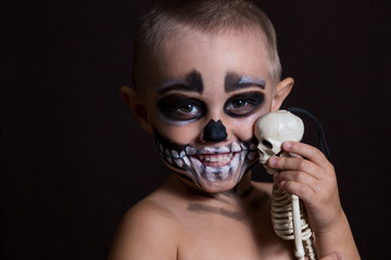Close-up portrait of a small child in scary makeup on a halloween party