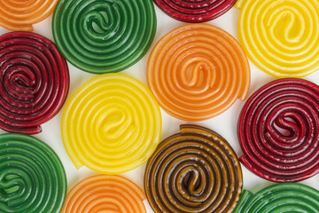 background of gummy candy spirals in orange, red, green and brown