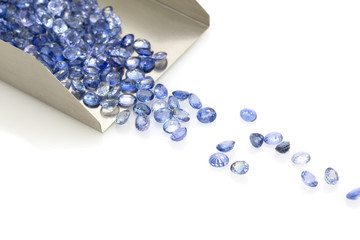 Precious blue sapphires on a jeweler's shovel. Precious polished stones. Set of many stones.