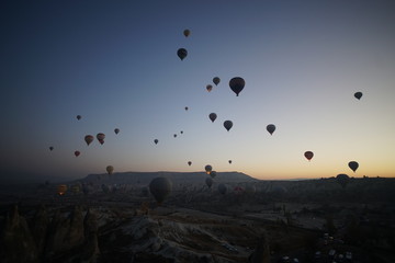 Hot air balloon flying over rock landscape at Cappadocia Turkey