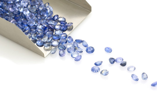 Precious blue sapphires on a jeweler's shovel. Precious polished stones. Set of many stones.
