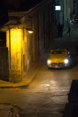 Old car on Havana street corner at night