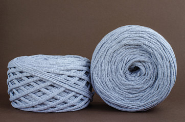 t-shirt yarn balls light gray color on brown background. Handmade craft recycle eco concept