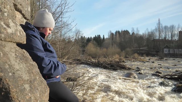 A middle-aged lady thinking on the side of the river in Vantaa Finland.4K