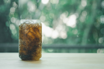 Fresh and cold soft drink in glass on wood table arrange on nature blur nature background