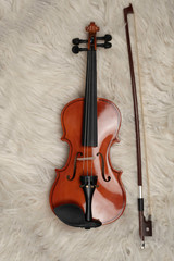 Fototapeta na wymiar Violin and bow put on silk velvet cloth,show detail of acoustic instrument