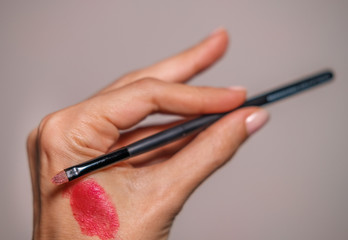 makeup equipment. Professional brushes. Color sample hands holding tools. Lip, shadows,blending, broncer tools
