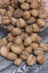 An overturned basket of walnuts. Against a background of painted pine boards.