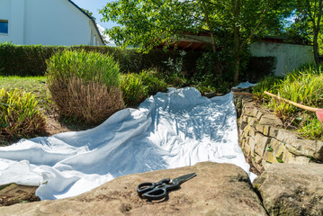 Laid underground foil for a stream with scissors in the foreground