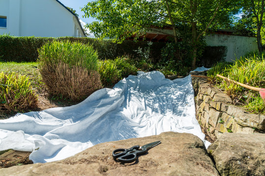 Laid underground foil for a stream with scissors in the foreground