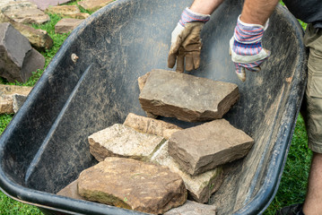 Worker takes stones from a wheelbarrow 