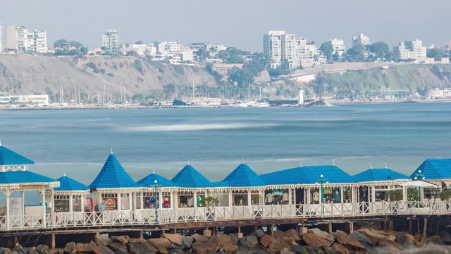 Aerial view of the Pier taken from the pebble beach. Restaurant is located at the end of the pier timelapse. Miraflores, Lima, Peru. City skyline on a background
