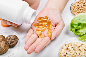 Obraz premium Vitamin nutrition pills on hand, Natural medicine supplement from organic fresh fruit, wholegrain cereals and vegetable, Healthy beauty food diet.
