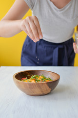 woman cooking healthy salad in a bowl