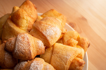 Homemade bakery in plate seasoned with sugar powder on wooden table
