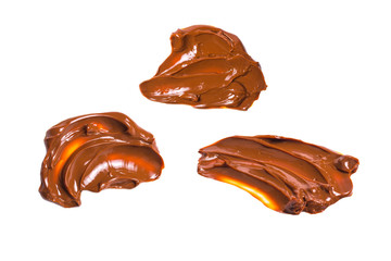 Melted tasty caramel splashes isolated on white background.