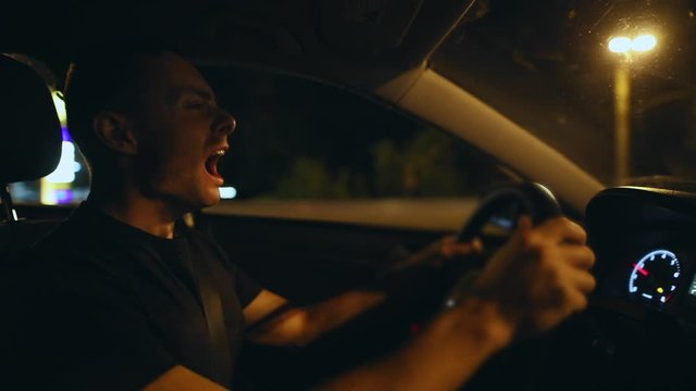 Tired man want to sleep when driving car and yawn